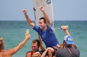 Staff photo by Cole Dittmer. Wrightsville Beach local Ben Bourgeois is greeted by a crowd of friends and family on the beach after winning the 9th annual O'Neill Sweetwater Pro-Am Sunday, July 13.