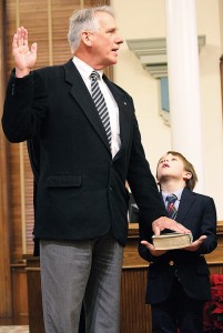 Staff photo by Cole Dittmer. Newly elected New Hanover County Commissioner Rob Zapple takes his oath of office with grandson Jameson Zapple during the commissioner’s meeting Monday, Dec. 22.
