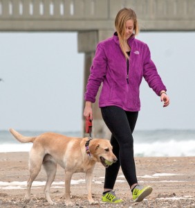 Staff photo by Emmy Errante. Sutton Hack walks her dog, Riley, on Wrightsville Beach Feb. 11. Discussing the town's dog regulations will be on the Board of Aldermen's retreat agenda Feb. 14.