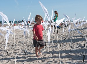 Staff photo by Allison Potter. Four-year-old Seth Perry walks through a model wind farm at the Hands Across the Sand event Saturday, May 16.