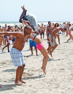 Staff photo by Emmy Errante. An impromptu chain of backflipping breaks out near Johnnie Mercer's Pier Saturday, July 4 at Wrightsville Beach.