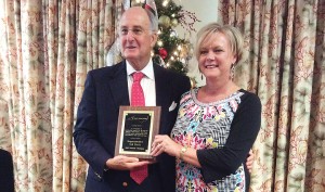 Supplied photo courtesy of the New Hanover County Tourism Development Authority. Kim Hufham, president and CEO of the New Hanover County Tourism Development Authority, presents Republican Rep. Ted Davis with the N.C. Travel & Tourism Coalition Tourism Champion Award on Friday, Dec. 18 at the Holiday Inn in Wrightsville Beach.